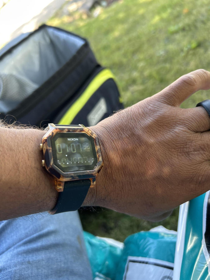 Man working outside and showing off his Nixon Siren digital watch