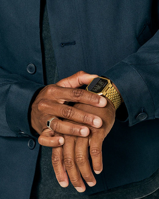 Man wearing an all gold Nixon Re-Run digital watch